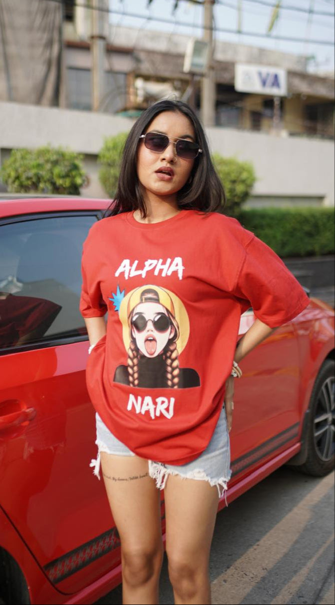 Woman wearing a red t-shirt with graphic design and text, standing next to a red car.